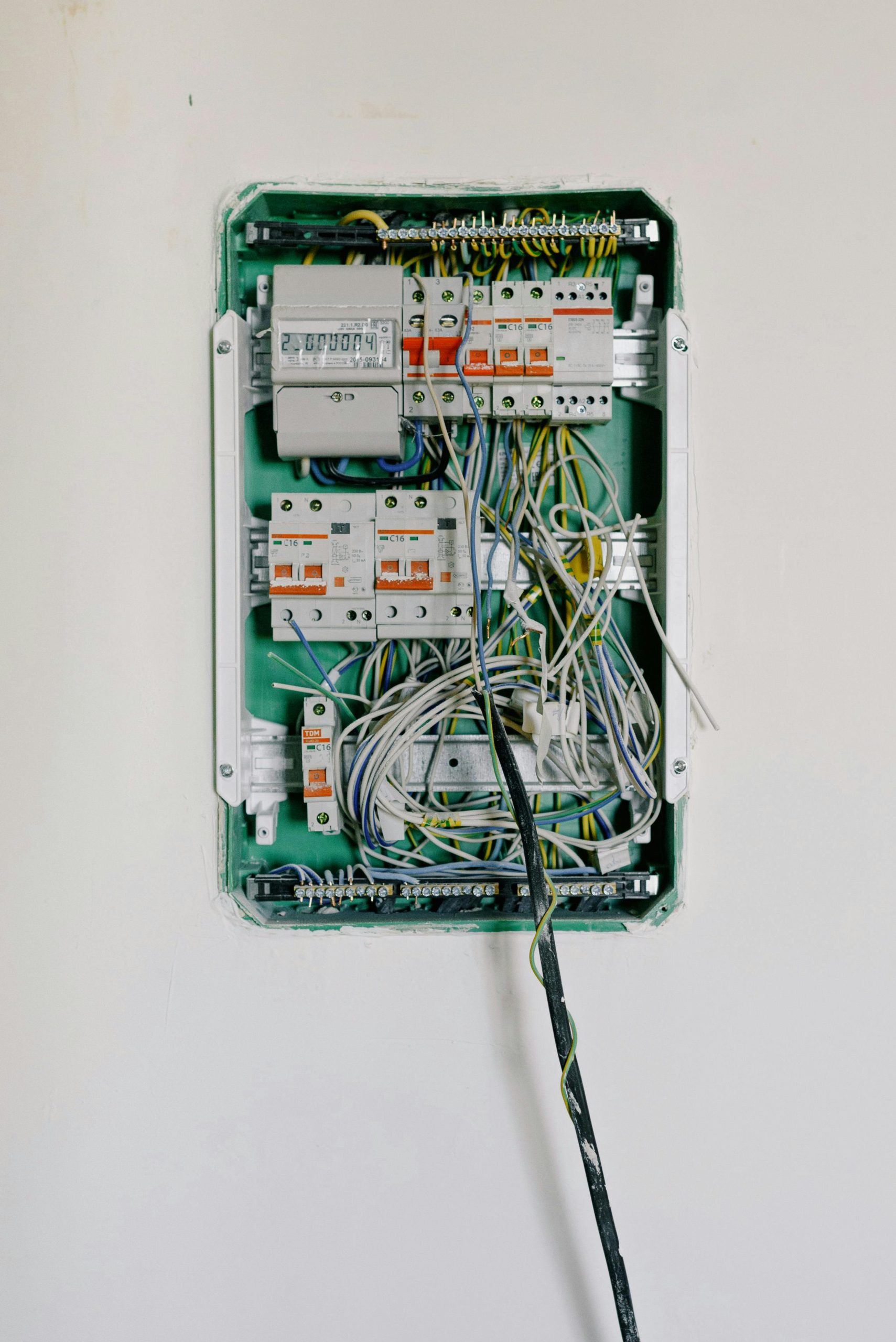 Detailed view of an open electrical circuit box with complex wiring and circuit breakers.